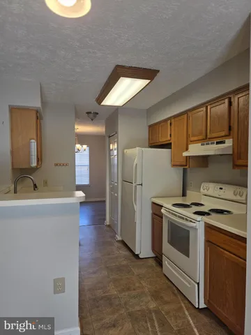 a kitchen with a stove a refrigerator and a sink