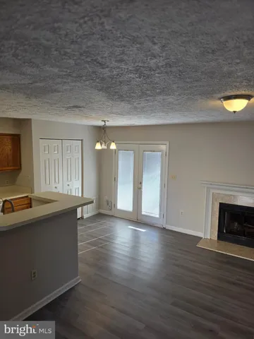 a view of a livingroom with wooden floor and a fireplace