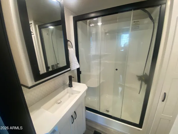 a bathroom with a shower sink and mirror