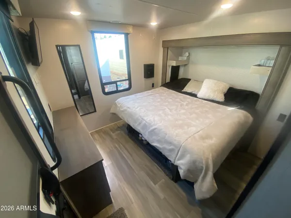 a large bed sitting in a bedroom next to a window