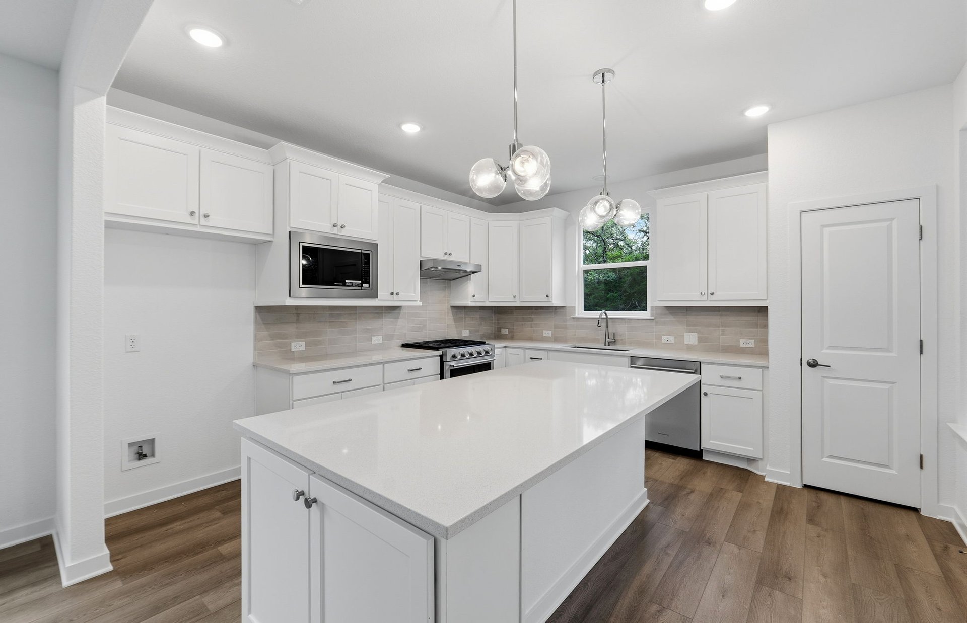 1010 Martingale Street Georgetown, TX 78633 - Photo 2 of 23 a kitchen with a sink a stove a microwave and cabinets