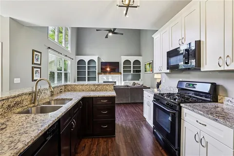 a kitchen with stainless steel appliances granite countertop a sink stove and cabinets