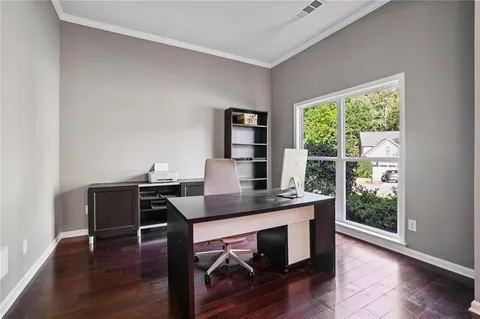 a view of a workspace with furniture and a window