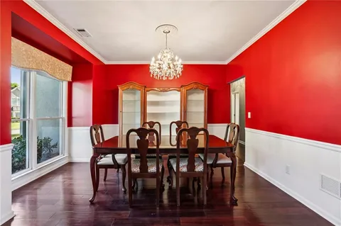 a view of a dining room with furniture a chandelier and wooden floor