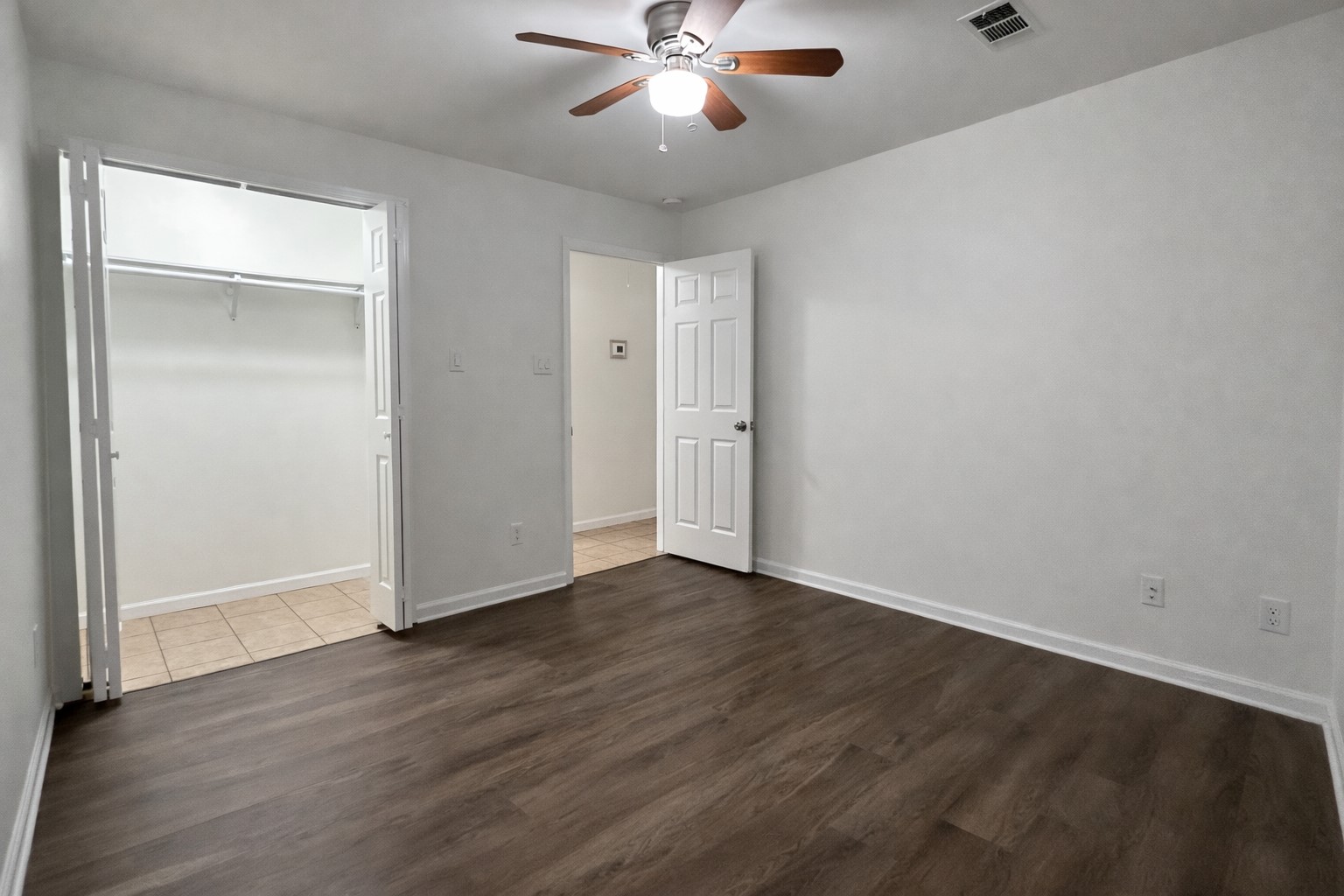 6619 Carver Road, Unit B Houston, TX 77091 - Photo 11 of 12 an empty room with wooden floor a ceiling fan and closet