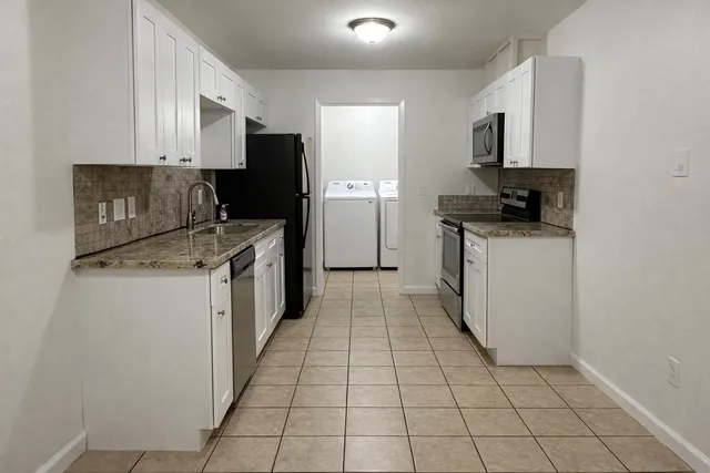 a kitchen with stainless steel appliances granite countertop a refrigerator and a stove
