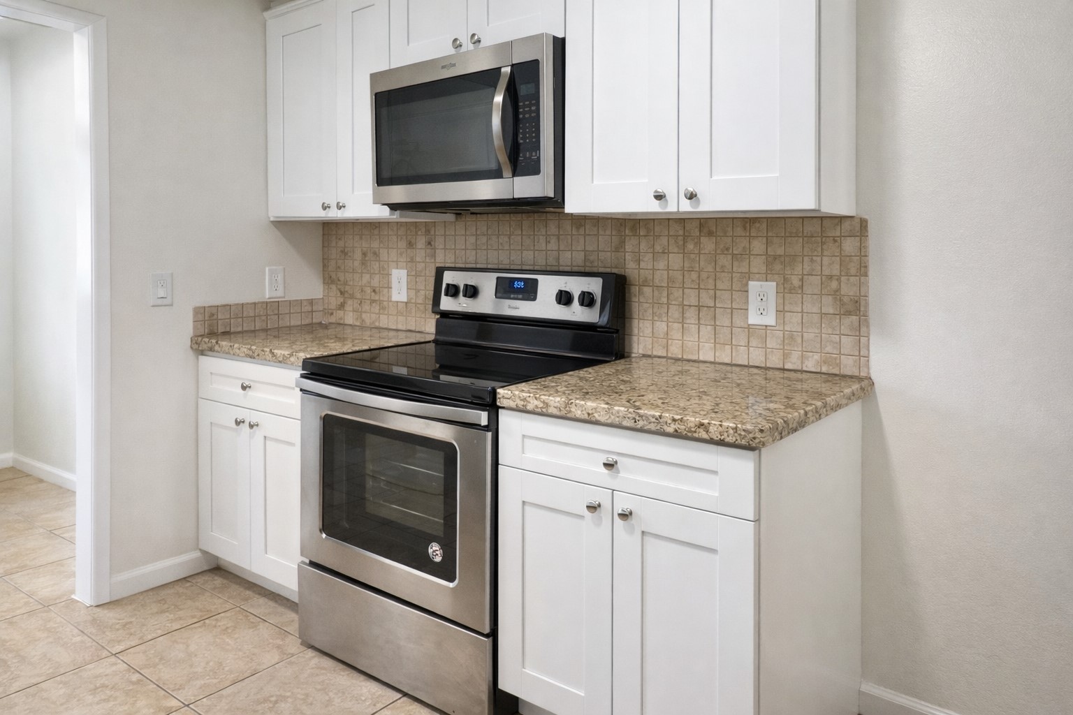 6619 Carver Road, Unit B Houston, TX 77091 - Photo 5 of 12 a kitchen with stainless steel appliances granite countertop white cabinets a microwave and a stove