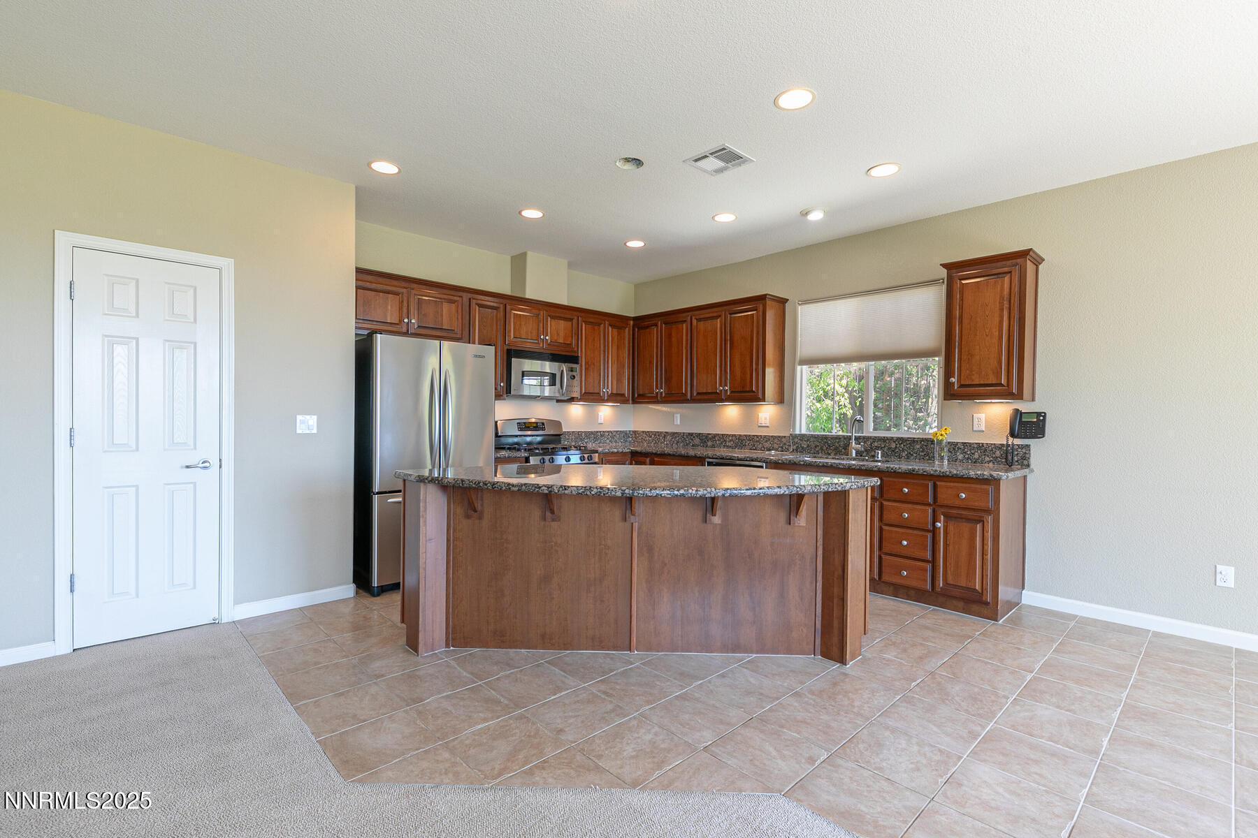 8890 Chipshot Trail Reno, NV 89523 - Photo 12 of 36 a open kitchen with stainless steel appliances granite countertop a refrigerator and a sink