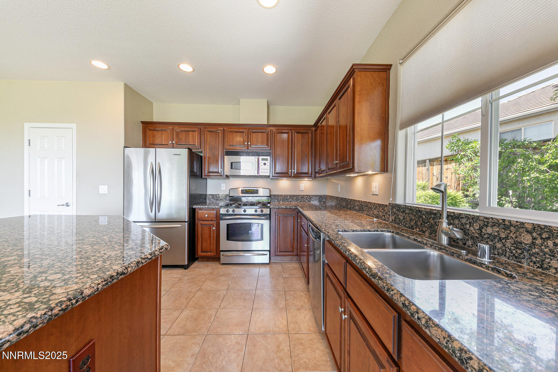 8890 Chipshot Trail Reno, NV 89523 - Photo 19 of 36 a kitchen with stainless steel appliances granite countertop a sink a stove and a refrigerator