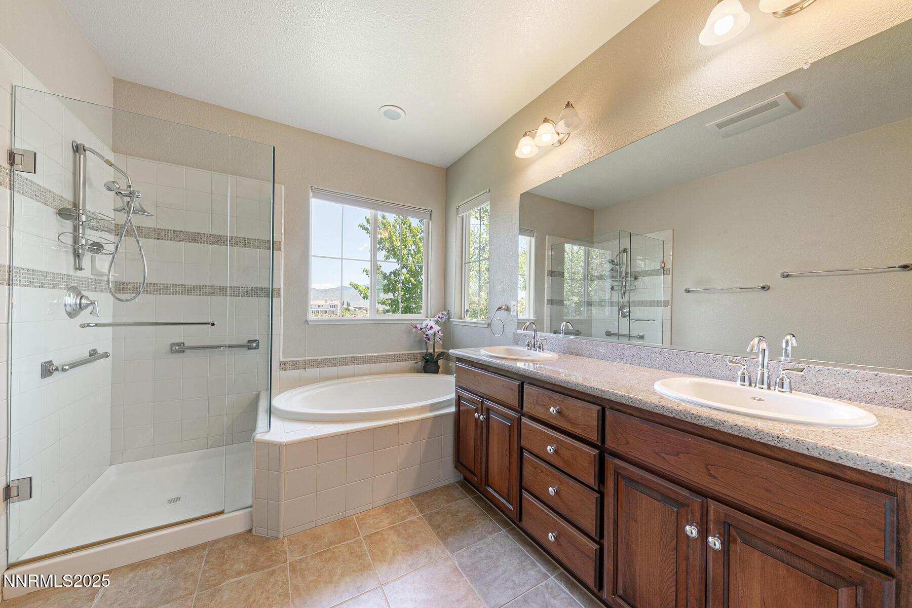 8890 Chipshot Trail Reno, NV 89523 - Photo 24 of 36 a bathroom with a double vanity sink a large mirror and shower