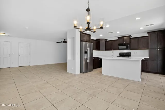 a kitchen with stainless steel appliances kitchen island granite countertop a refrigerator and a stove top oven