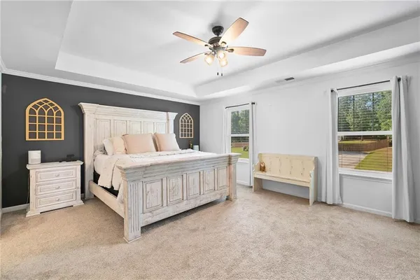a bedroom with a white bed and a large window