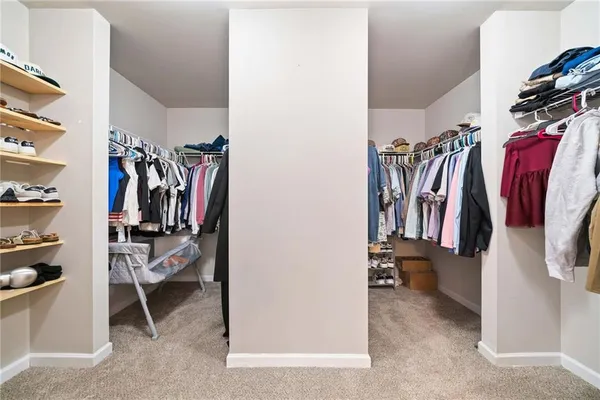a view of walk in closet with clothes and shoes