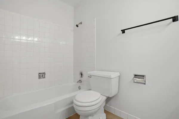 a white toilet sitting next to a bath tub