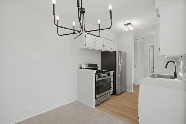 a kitchen with stainless steel appliances granite countertop a sink a stove a refrigerator and cabinets