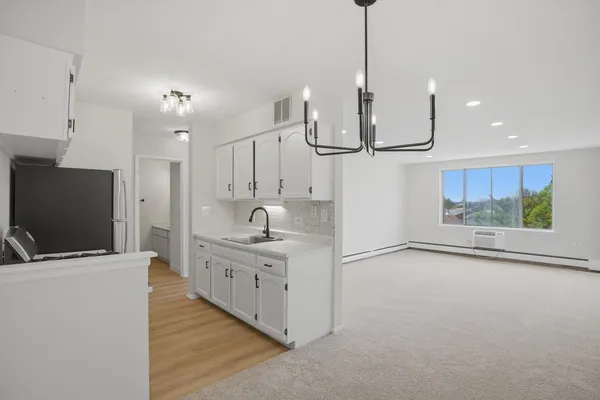a kitchen with stainless steel appliances kitchen island sink refrigerator and cabinets