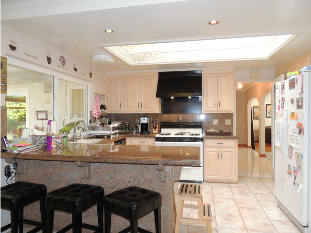1811 Randall Road San Mateo, CA 94402 - Photo 7 of 21 a kitchen with stainless steel appliances kitchen island granite countertop a sink and cabinets