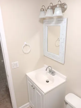 a bathroom with a sink toilet and mirror