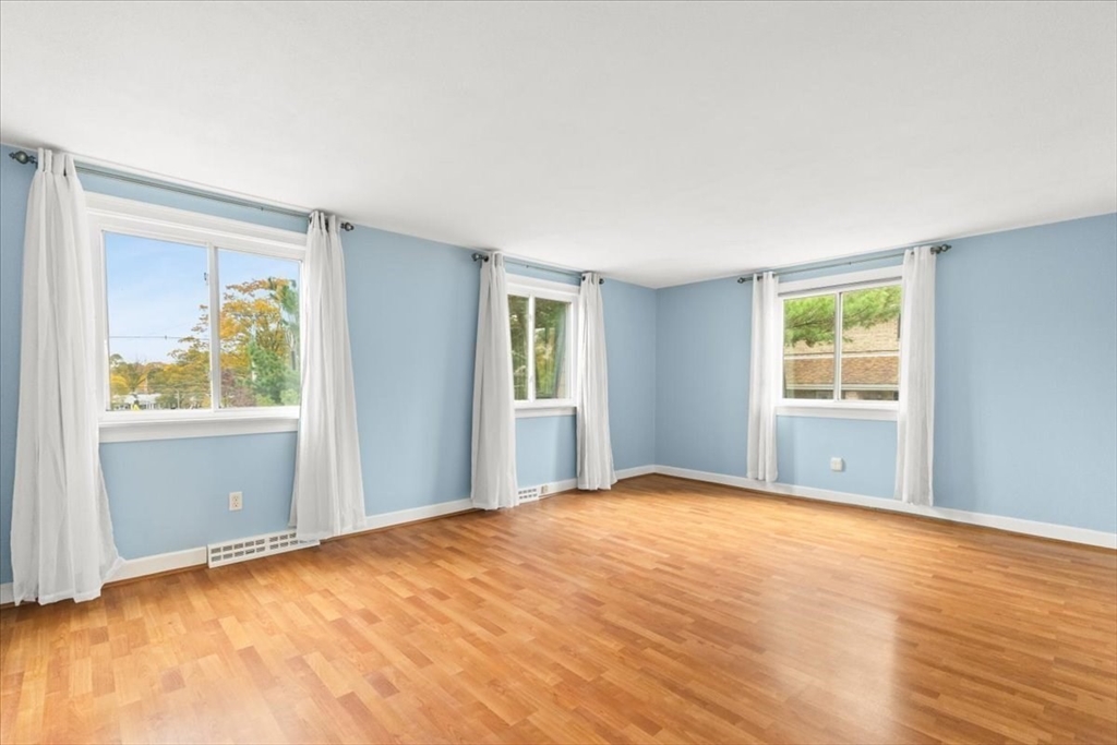 212 Washington Street, Unit 212 Canton, MA 02021 - Photo 17 of 35 a view of an empty room with wooden floor and a window