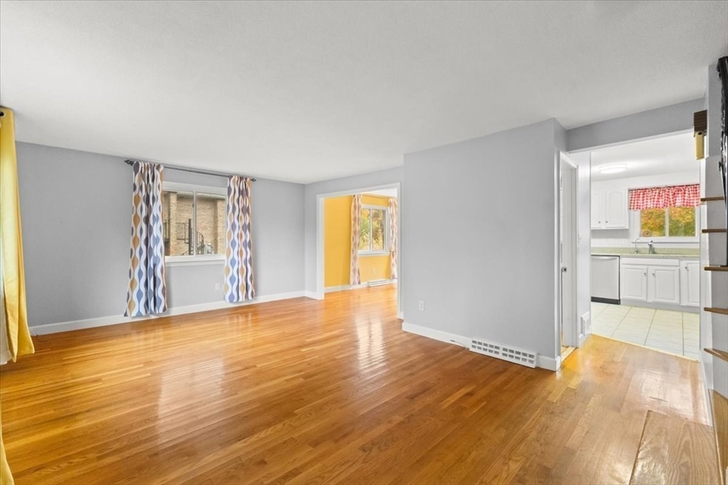212 Washington Street, Unit 212 Canton, MA 02021 - Photo 3 of 35 a view of an empty room with wooden floor and a window