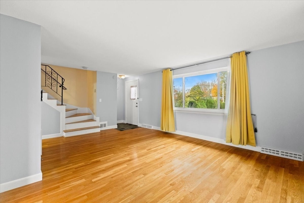 212 Washington Street, Unit 212 Canton, MA 02021 - Photo 4 of 35 a view of an empty room with wooden floor and a window