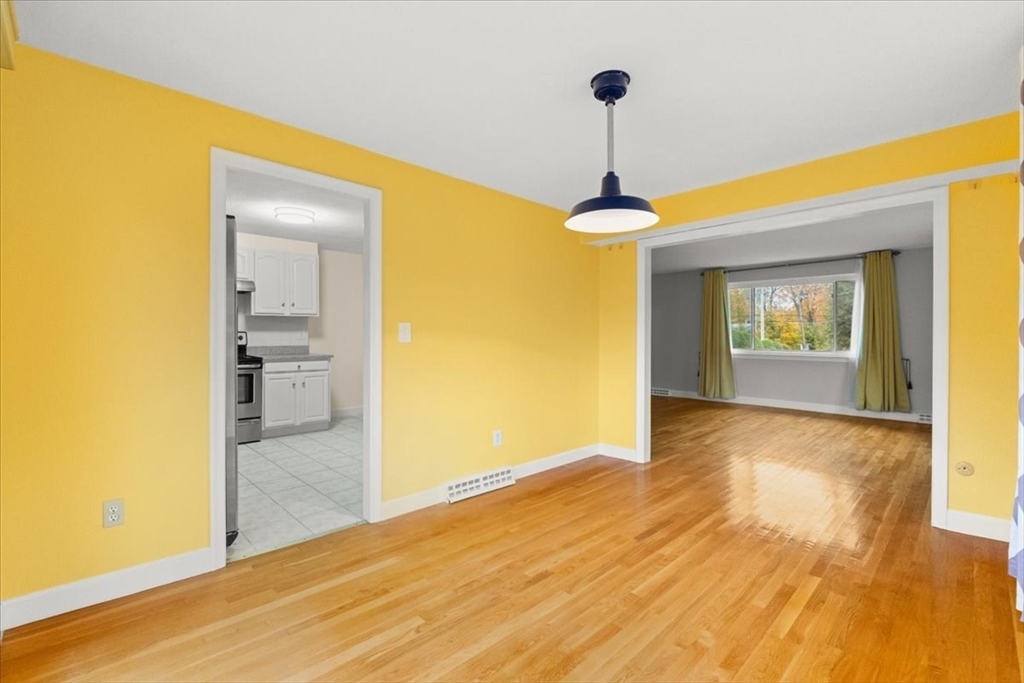212 Washington Street, Unit 212 Canton, MA 02021 - Photo 8 of 35 a view of a hallway with wooden floor and a dining room
