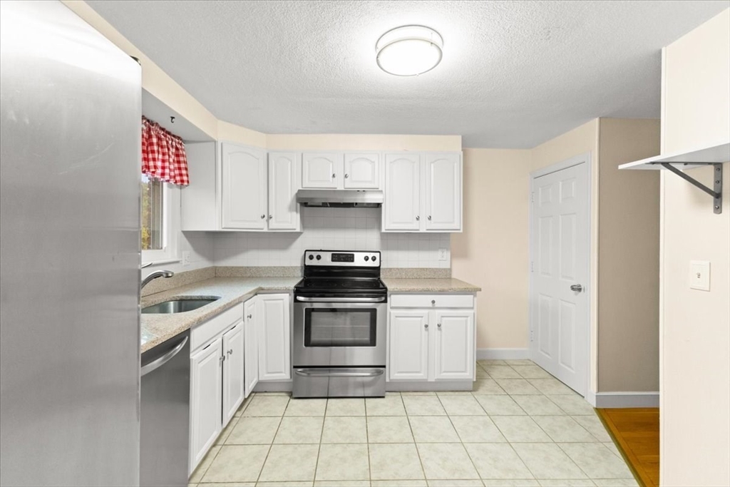 212 Washington Street, Unit 212 Canton, MA 02021 - Photo 9 of 35 a kitchen with a stove top oven sink and cabinets
