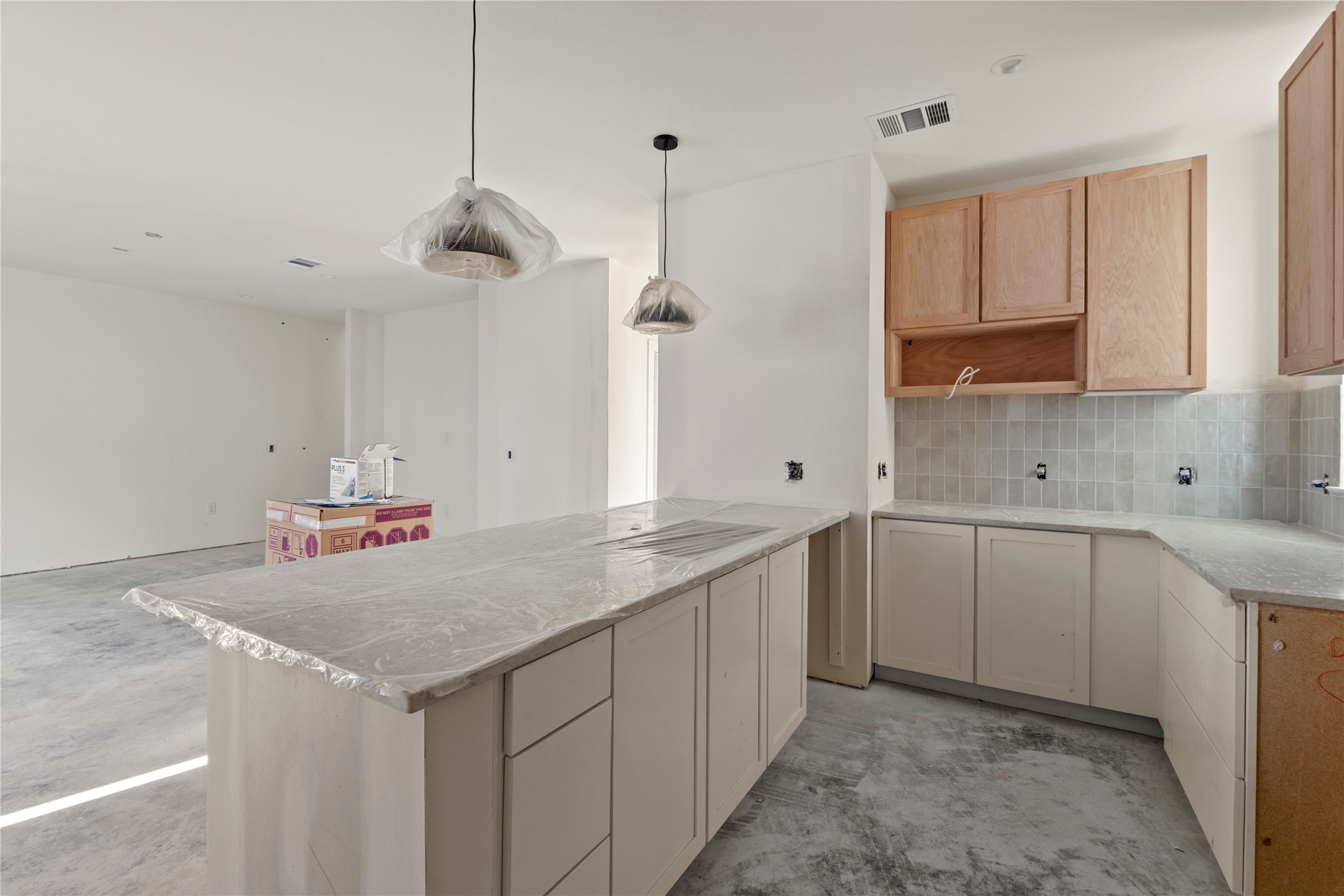 1180 Lott Avenue Austin, TX 78721 - Photo 4 of 40 Kitchen with concrete floors, backsplash, hanging light fixtures, a peninsula, and light stone counters