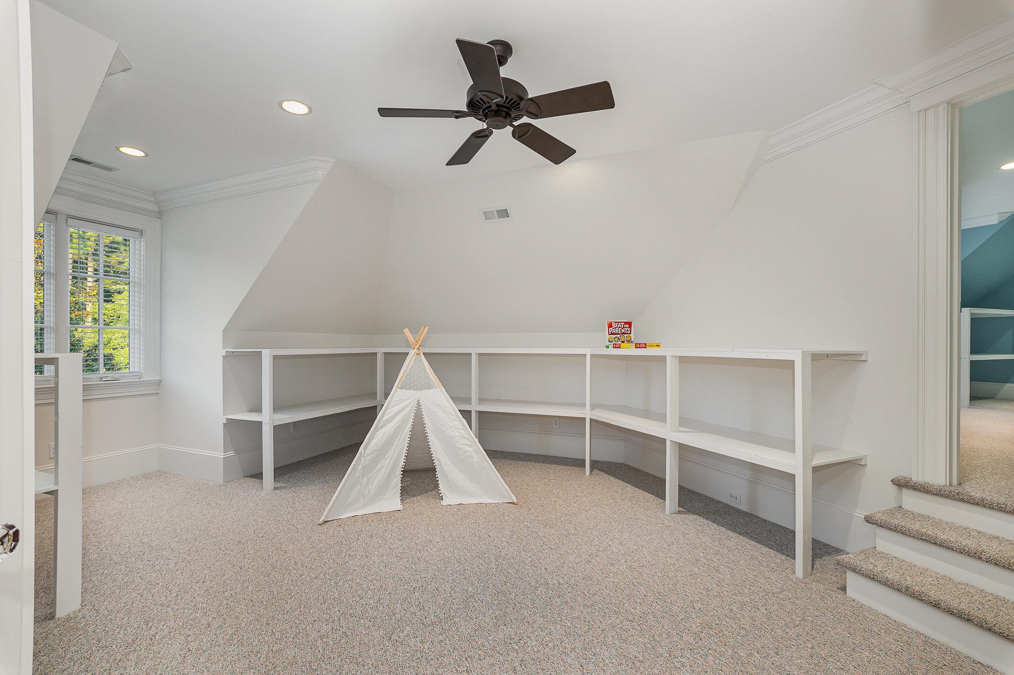7728 Grace Cove Lane Raleigh, NC 27613 - Photo 55 of 82 a view of room with stairs and a ceiling fan