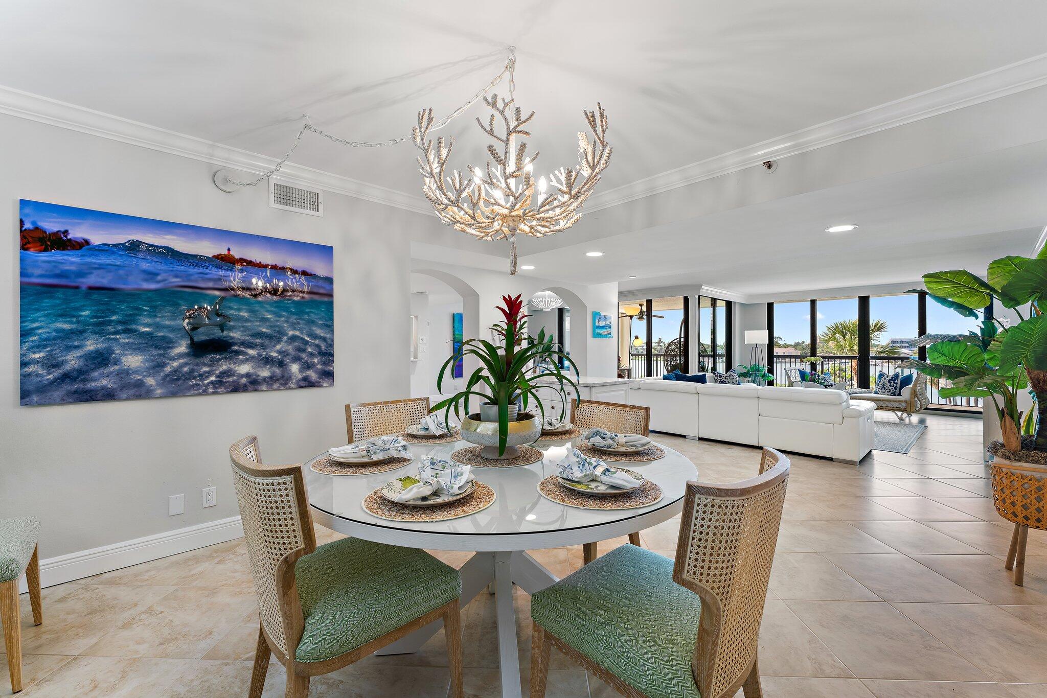 19670 South Beach Road, Unit B303 Jupiter, FL 33469 - Photo 24 of 104 a view of a dining room with furniture a chandelier and wooden floor