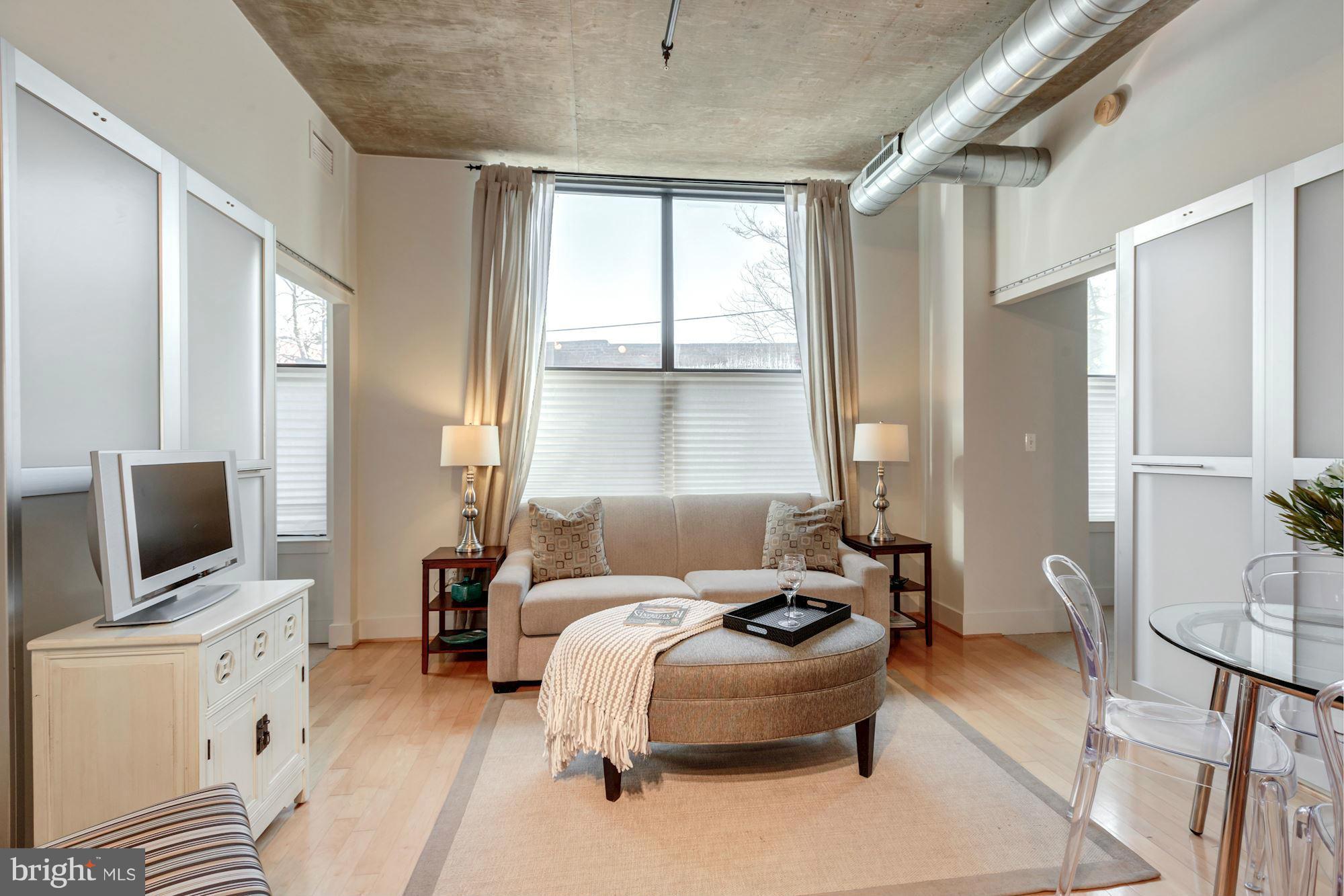 2301 Champlain Street Northwest, Unit 112 Washington, DC 20009 - Photo 1 of 29 a living room with furniture a flat screen tv and a window