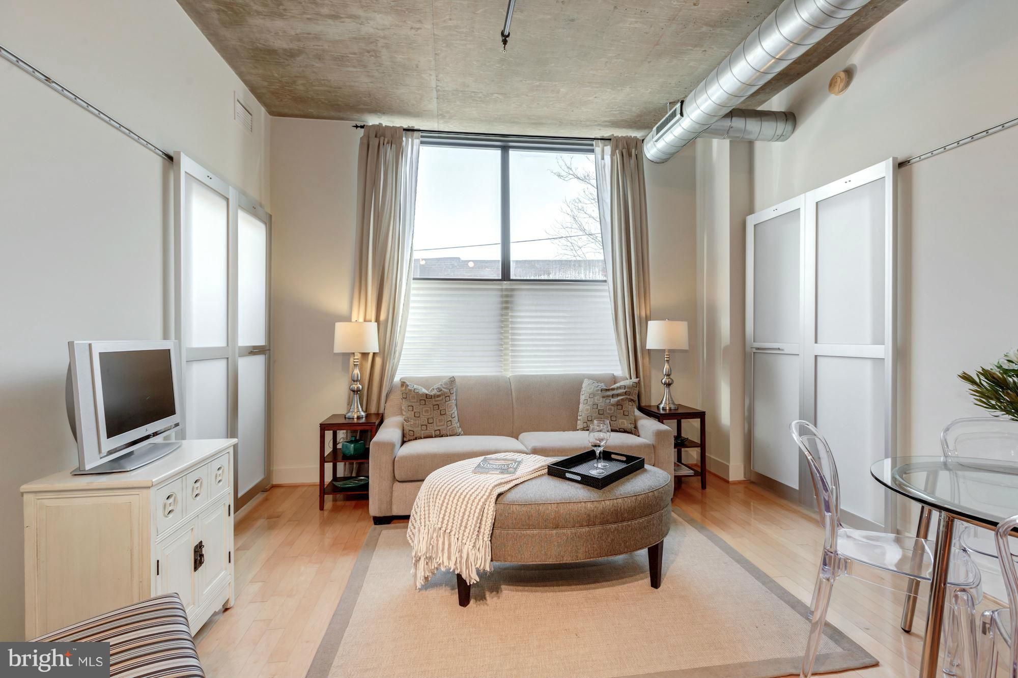 2301 Champlain Street Northwest, Unit 112 Washington, DC 20009 - Photo 2 of 29 a living room with furniture a flat screen tv and a large window