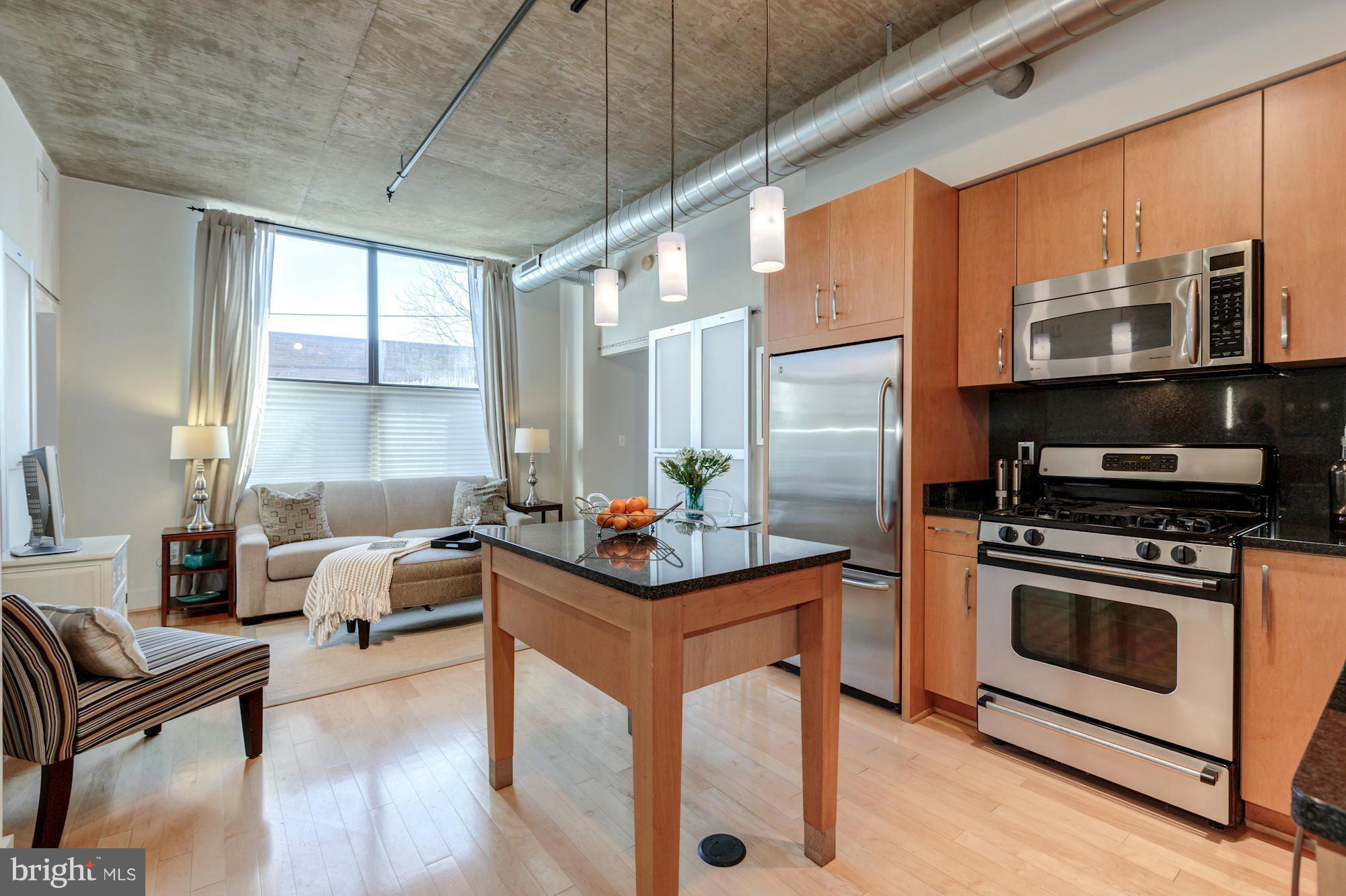 2301 Champlain Street Northwest, Unit 112 Washington, DC 20009 - Photo 12 of 29 a kitchen with stainless steel appliances kitchen island granite countertop a stove a sink and a refrigerator