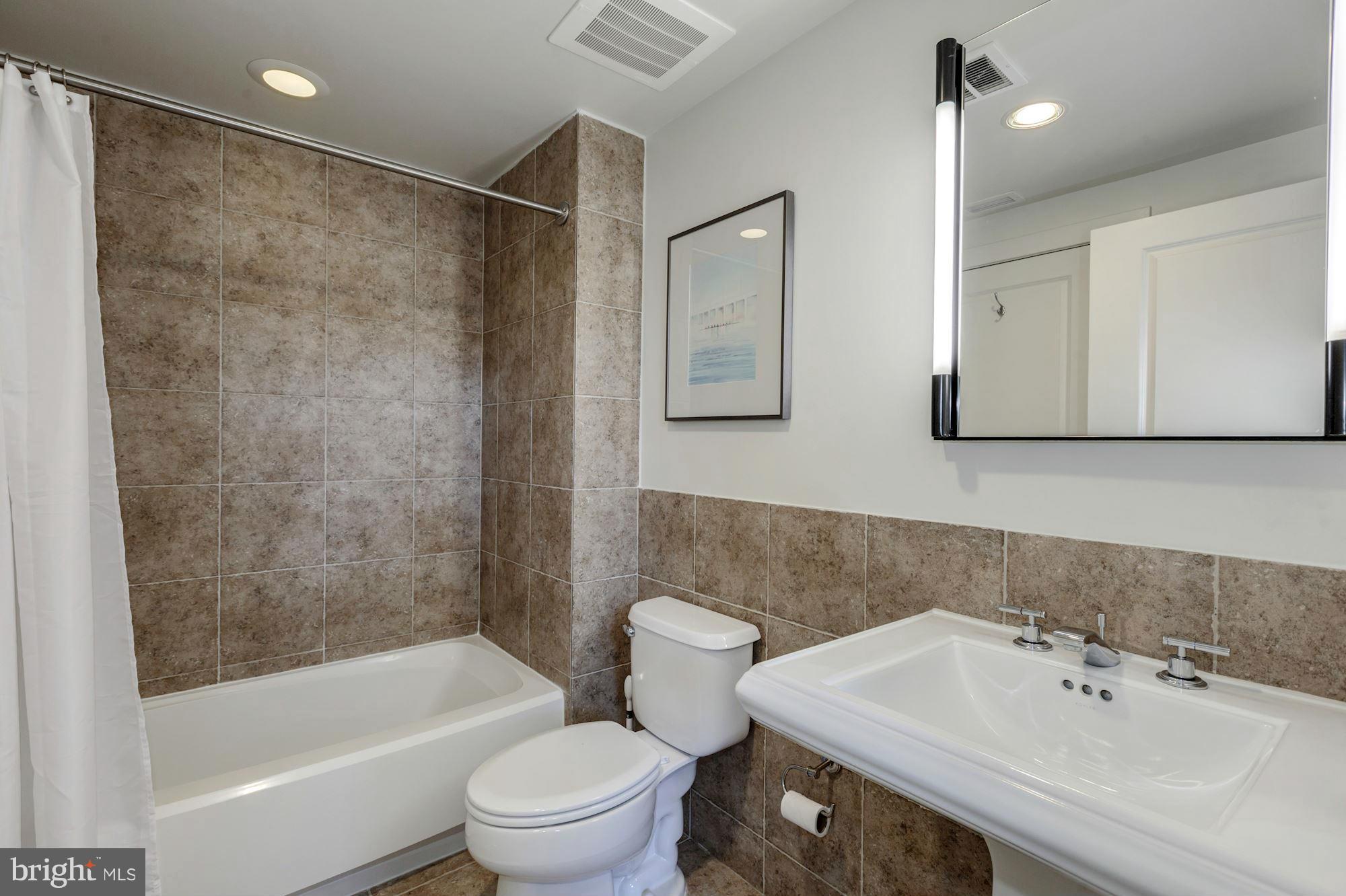2301 Champlain Street Northwest, Unit 112 Washington, DC 20009 - Photo 16 of 29 a bathroom with a sink toilet and shower