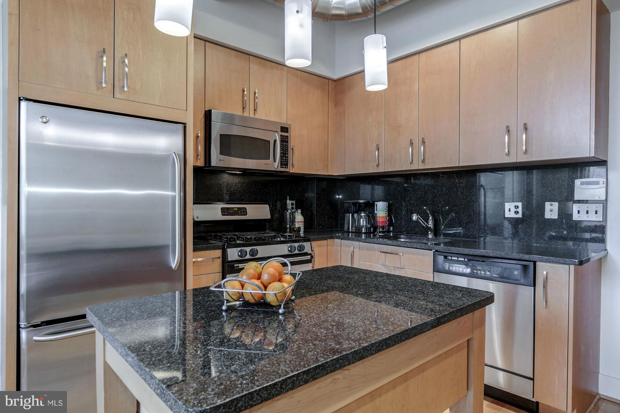 2301 Champlain Street Northwest, Unit 112 Washington, DC 20009 - Photo 8 of 29 a kitchen with stainless steel appliances granite countertop a sink a stove and a refrigerator
