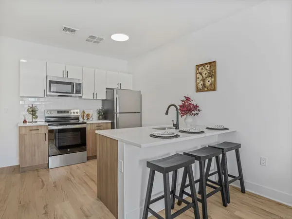 a kitchen with a table chairs refrigerator and microwave