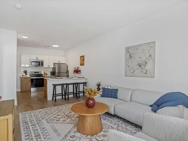 a living room with furniture and a view of kitchen