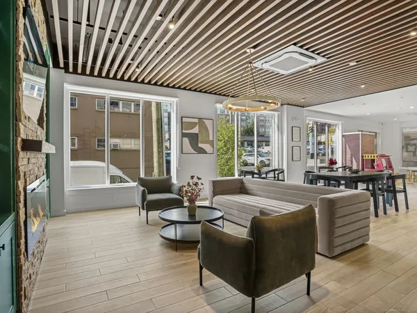 a living room with furniture a large window and wooden floor