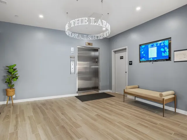 a view of a hallway with wooden floor and a chandelier
