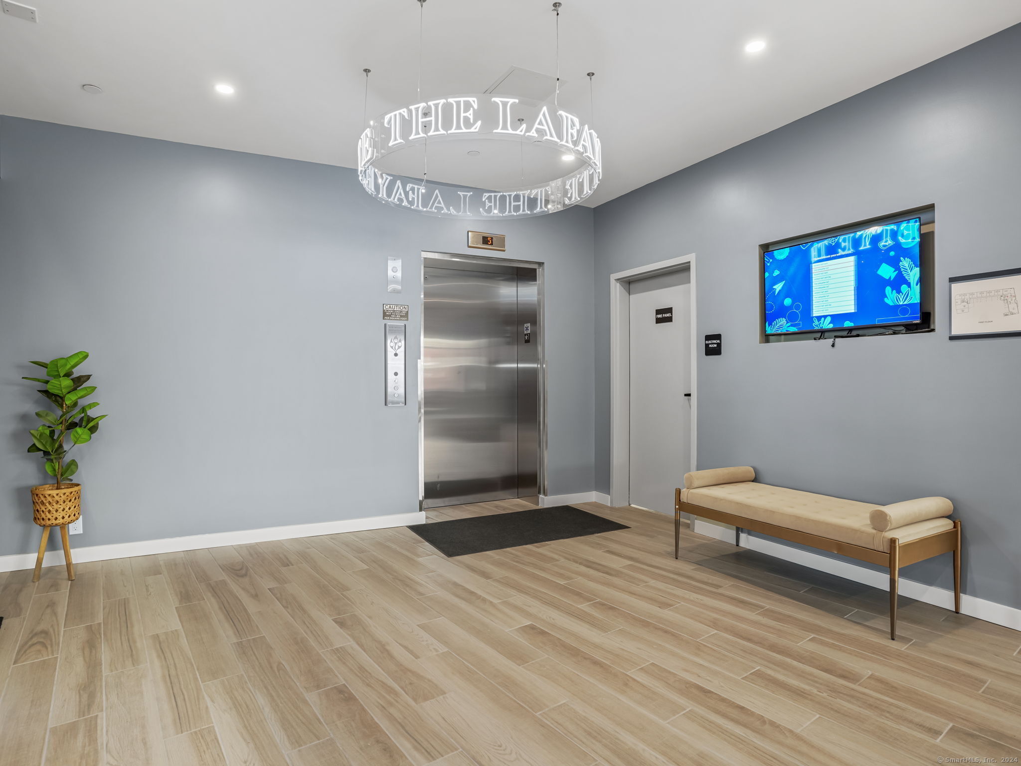 821 East Main Street, Unit 209 Stamford, CT 06902 - Photo 9 of 29 a view of a hallway with wooden floor and a chandelier