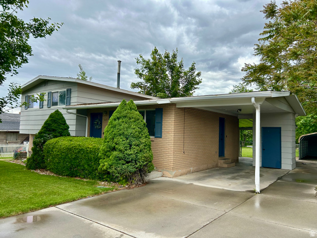 441 South 400 East Payson, UT 84651 - Photo 1 of 39 Split-level residence featuring a brick and siding exterior, established foundation landscaping, and a covered carport with a concrete drive