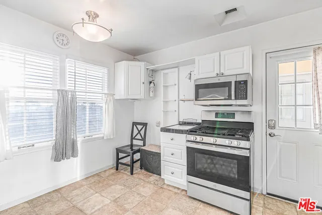 a kitchen with cabinets stainless steel appliances and wooden floor