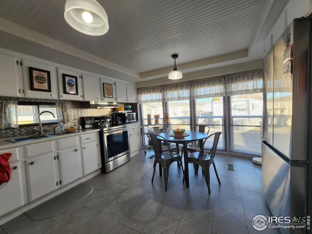 a kitchen with a table chairs sink and cabinets