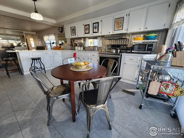 a view of a dining room with furniture and a kitchen