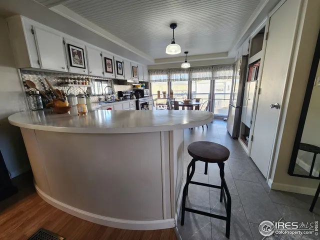 a close view of dining table chairs and entryway with wooden floor