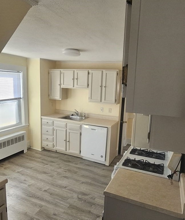22 Endicott Street, Unit 3 Norwood, MA 02062 - Photo 2 of 22 a kitchen with a cabinets and wooden floor
