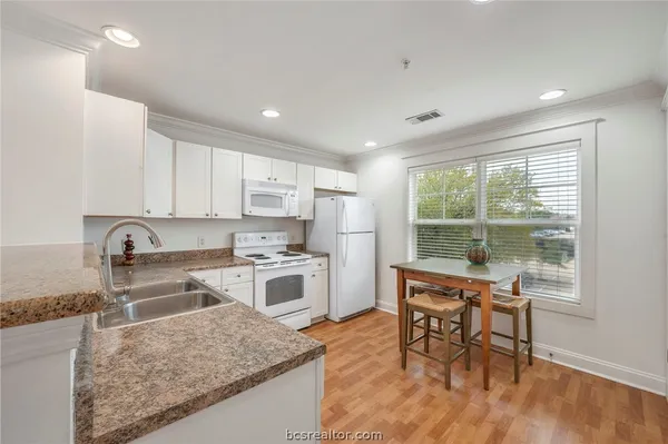 a kitchen with stainless steel appliances granite countertop sink stove top oven and cabinets
