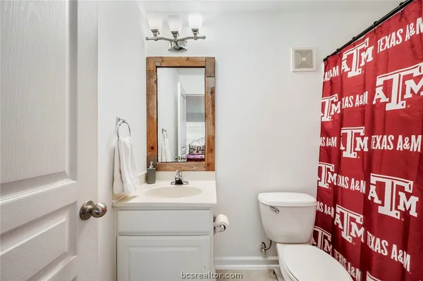 a bathroom with a toilet sink and mirror