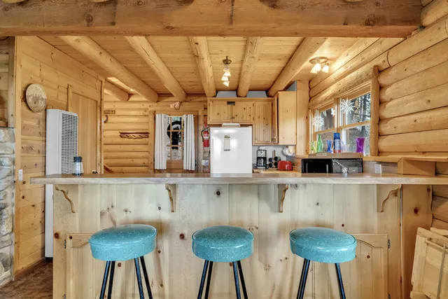 a kitchen with stainless steel appliances a table chairs and a wooden cabinets