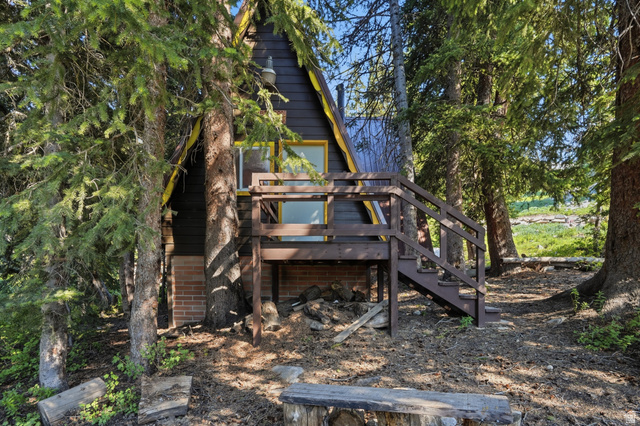 8505 South Snake Crk Road Salt Lake City, UT 84121 - Photo 41 of 67 A-frame cabin featuring a dark exterior, brown deck with railings, and a brick foundation